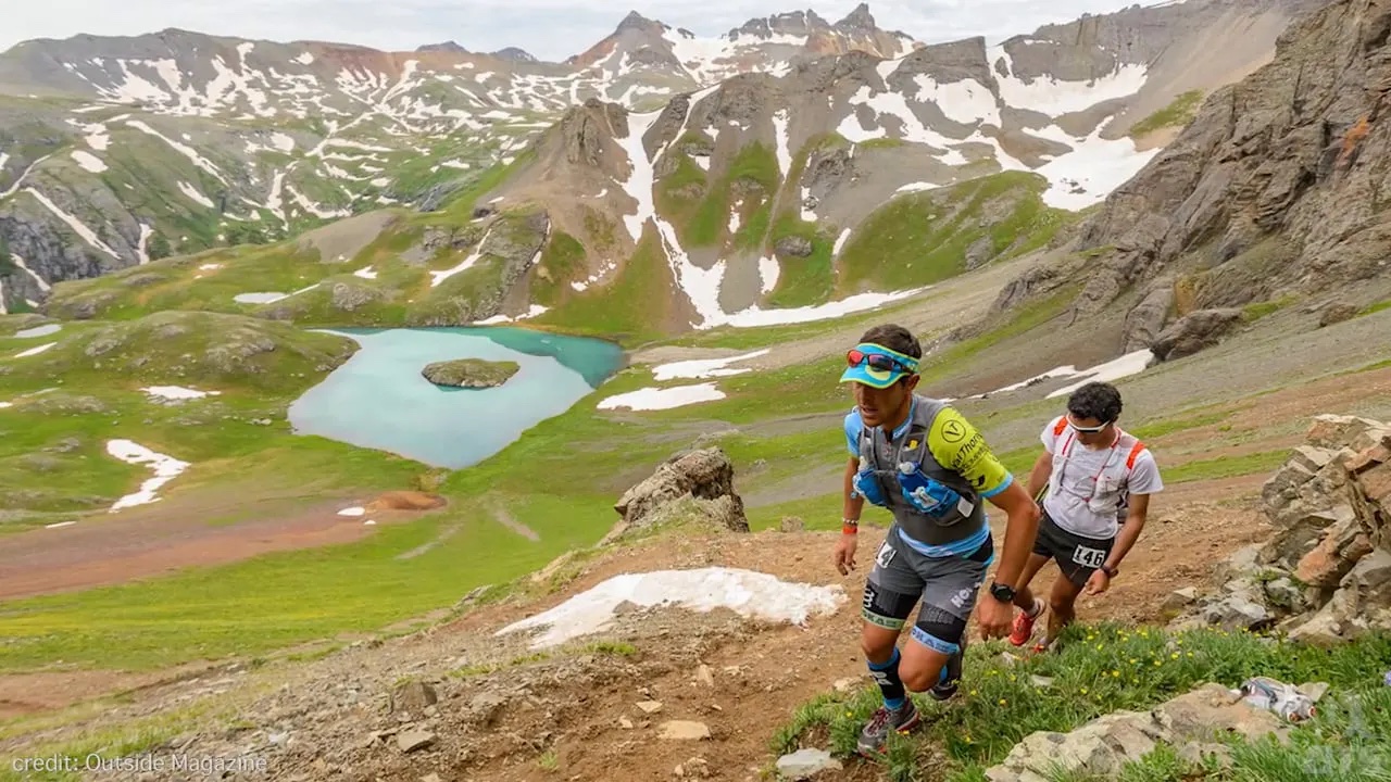 Runners hiking up above an alpine lake on the way to grant swamp pass. Photo credit: letsdothis.com